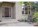 Inviting front porch with brick facade, large window, and outdoor seating at 10375 Lions Heart, Lone Tree, CO 80124