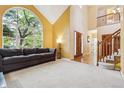 Bright living room with large arched window, vaulted ceiling, and staircase access at 10375 Lions Heart, Lone Tree, CO 80124