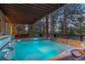 Relaxing hot tub on a covered deck with forest views, perfect for outdoor enjoyment at 7192 Pinewood Dr, Evergreen, CO 80439