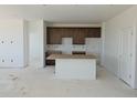 Spacious kitchen area with cabinets and island, awaiting appliances and finishing at 6034 Keyser Pl, Brighton, CO 80601