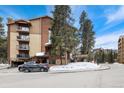 Exterior view of the condo building with snow, sign, and beautiful mountain landscape at 720 Columbine Rd # B, Breckenridge, CO 80424