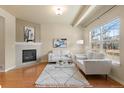 Bright living room featuring hardwood floors, a fireplace, and large windows, creating a warm and inviting atmosphere at 1212 S Emery St # C35, Longmont, CO 80501