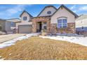 Two-story house with stone accents and a landscaped yard at 8731 Zircon Way, Arvada, CO 80007