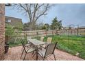 Outdoor dining space in a beautiful backyard with wooden fence and well-manicured lawn at 3633 S Ingalls St, Denver, CO 80235