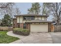 Two-story home with a brick facade, tudor accents, a driveway and a two-car garage at 3633 S Ingalls St, Denver, CO 80235