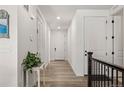 Bright hallway featuring hardwood floors, white walls, and paneled doors, leading to various rooms at 4089 Forever Cir, Castle Rock, CO 80109