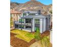 Modern home featuring a large balcony and lush green lawn in a picturesque setting at 8132 Galileo Way, Littleton, CO 80125
