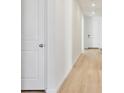 Bright hallway featuring sleek laminate floors, fresh white paint, and modern doors, adding a touch of elegance at 200 Lark Sparrow Way, Bennett, CO 80102