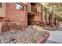 Brick condo building exterior with rocks and stone pathway leading to stairs and covered entrance at 420 Wright St # 101, Lakewood, CO 80228