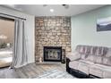 Living room showing the beautiful stone fireplace, couch and patio door at 420 Wright St # 101, Lakewood, CO 80228