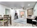 Bright living room featuring a stone fireplace, ceiling fan and sliding glass door to a patio at 420 Wright St # 101, Lakewood, CO 80228