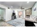 Open-concept living room features hardwood floors, stone fireplace, and light gray walls at 420 Wright St # 101, Lakewood, CO 80228