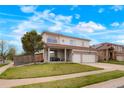 Inviting two-story home with a covered front porch, two-car garage, and landscaped lawn at 20292 E 47Th Ave, Denver, CO 80249