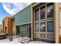 Townhouse exterior with neutral trim, sage siding, and multiple windows reflecting cloudy skies at 4950 Homestead Pl # 23, Thornton, CO 80229