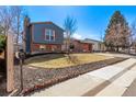Beautiful two-story home featuring brick, blue wood, large windows, and well-kept landscaping at 19228 E Arizona Pl, Aurora, CO 80017