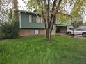 Two-story home with brick accents, attached garage, tree in the front yard at 880 Orion Dr, Lafayette, CO 80026