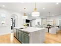 Open concept kitchen features a marble island with sink and modern pendant lighting at 1164 S High St, Denver, CO 80210