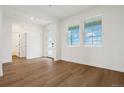 Bright living room featuring wood floors, white walls, and natural light from large windows at 42958 Colonial Trl, Elizabeth, CO 80107