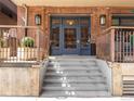 Building entrance featuring brick facade, glass door with visible signage, and concrete steps at 1449 Wynkoop St # 305, Denver, CO 80202