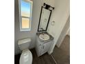 Bathroom featuring a modern vanity, granite countertop, stylish mirror, and a window for natural light at 59440 E 56Th Ave, Strasburg, CO 80136