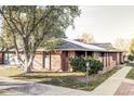 Spacious single-story brick home with manicured landscaping, mature trees, and inviting sidewalk at 3483 S Race St, Englewood, CO 80113