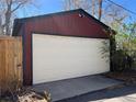 Spacious detached garage with a white door complementing the red exterior at 231 W Ellsworth Ave, Denver, CO 80223