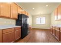 Bright kitchen featuring wood cabinets, light countertops, modern appliances, and hardwood floors at 9814 Norfolk St, Commerce City, CO 80022