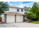 Beautiful residence displaying a two-car garage, mature evergreens, and a landscaped yard at 1775 S Memphis St, Aurora, CO 80017