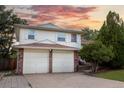 Charming two-story home featuring a brick-accented two-car garage and a well-manicured lawn at 1775 S Memphis St, Aurora, CO 80017