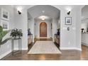 Grand foyer with arched doorway, hardwood floors, decorative rug, and elegant light fixtures at 171 Columbine St, Larkspur, CO 80118