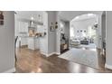 Open-concept living room and kitchen with hardwood floors, white cabinets, and modern appliances at 171 Columbine St, Larkspur, CO 80118