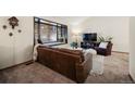 Cozy living room featuring a leather couch, window seat, and TV at 3420 S Nucla Way, Aurora, CO 80013