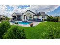 Inviting outdoor space showcasing a luxurious pool, ample seating, and manicured green lawn at 2705 Fox View Trl, Franktown, CO 80116