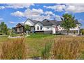 Striking home exterior featuring lush green grass, tasteful landscaping, and architectural details at 2705 Fox View Trl, Franktown, CO 80116