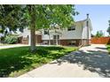 Welcoming two-story home featuring a lush green lawn and a long driveway at 4604 Routt St, Wheat Ridge, CO 80033
