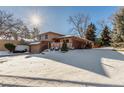 The home features a two-story structure with a two-car garage and an inviting, snowy front yard at 7318 W Cedar Cir, Lakewood, CO 80226