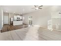 Bright open-concept living space with modern kitchen, recessed lighting, and sliding glass door to the outdoors at 2985 Oxley St, Strasburg, CO 80136