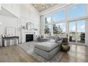 Bright living room with vaulted ceilings, a fireplace, and large windows overlooking the outdoor view at 423 N Snowmass Cir, Superior, CO 80027