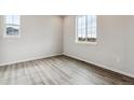 Bright bedroom with wood-look flooring and a large window offering natural light at 14441 Clover Dr, Mead, CO 80504