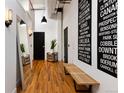 Hallway with high ceilings, wooden floors, wall decor, and a modern bench at 2955 Inca St # 2F, Denver, CO 80202