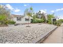 Inviting home with stone landscaping, metal planters, and healthy small trees at 1645 Wabash St, Denver, CO 80220