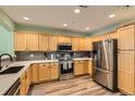 Spacious kitchen with stainless steel appliances, light wood cabinets, and quartz countertops at 1727 N Pearl St # 107, Denver, CO 80203
