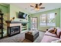 Cozy living room featuring a fireplace, ceiling fan, and a balcony overlooking the city at 1727 N Pearl St # 107, Denver, CO 80203