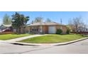 A charming brick home features an attached garage, a green lawn, and easy street access at 2698 Fern Dr, Westminster, CO 80030