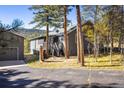 Home exterior with a porch and stairs, surrounded by mature trees at 31948 Highway 72, Golden, CO 80403