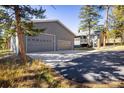 Large detached garage with a long driveway and house in background at 31948 Highway 72, Golden, CO 80403