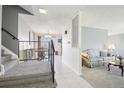 Bright foyer with staircase, neutral tile, and views into the dining and living areas at 12097 E Mexico Ave, Aurora, CO 80012