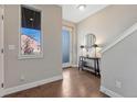 Bright foyer featuring wood floors, staircase, modern decor, window and neutral paint, creating a welcoming entrance at 5654 N Emporia St, Denver, CO 80238