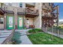 Charming front yard with a vibrant green lawn, garden bed, small decorative tree, and a cozy patio area at 5654 N Emporia St, Denver, CO 80238