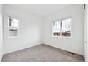 Bright, carpeted bedroom with two windows and a view of the neighborhood at 6966 E 126Th Pl, Thornton, CO 80602